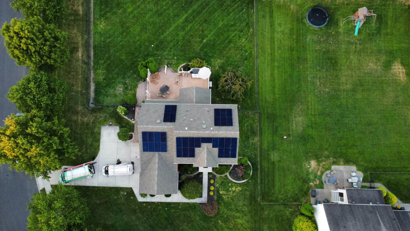 Bird's-eye view of a home with numerous solar panels on the roof, capturing clean energy.