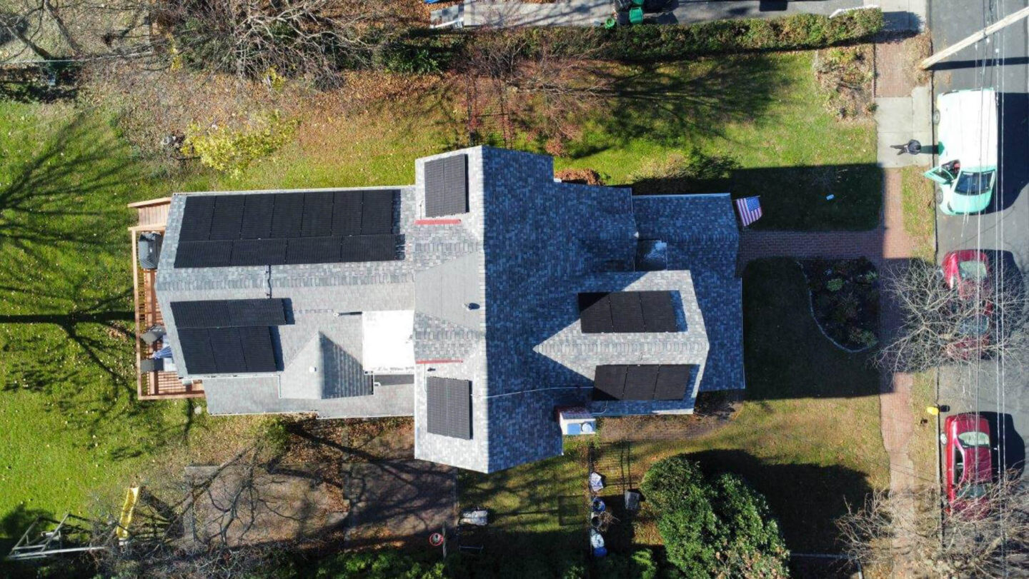 Aerial view of a home with solar panels installed by Venture Home installers, showcasing the roof's clean energy system.
