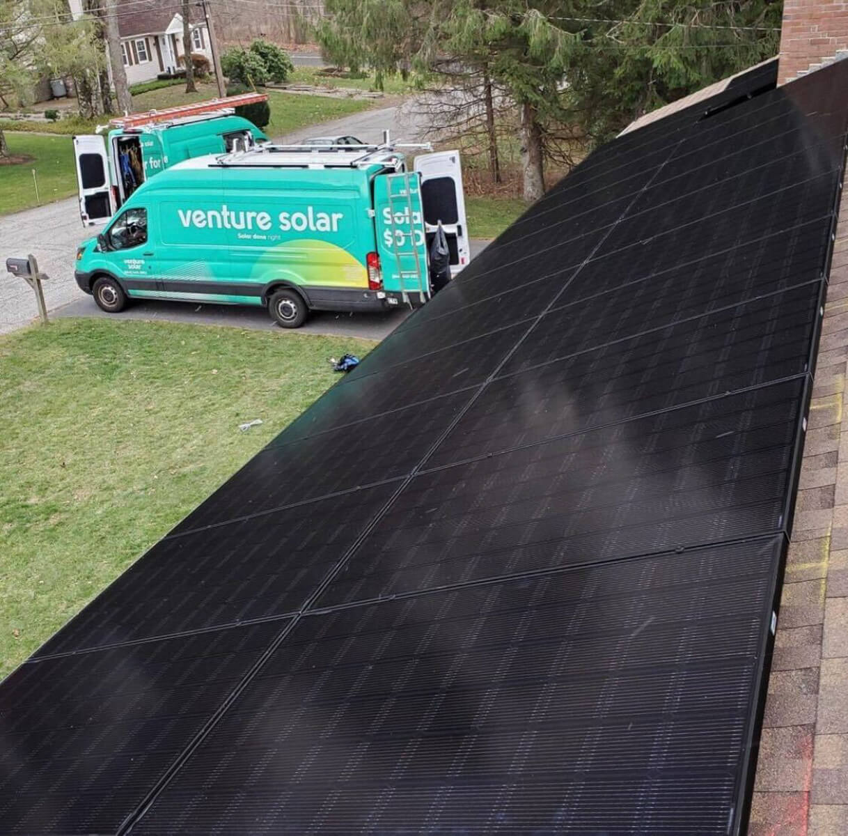 Venture Home vehicles parked outside a home with solar panels installed by their expert team.