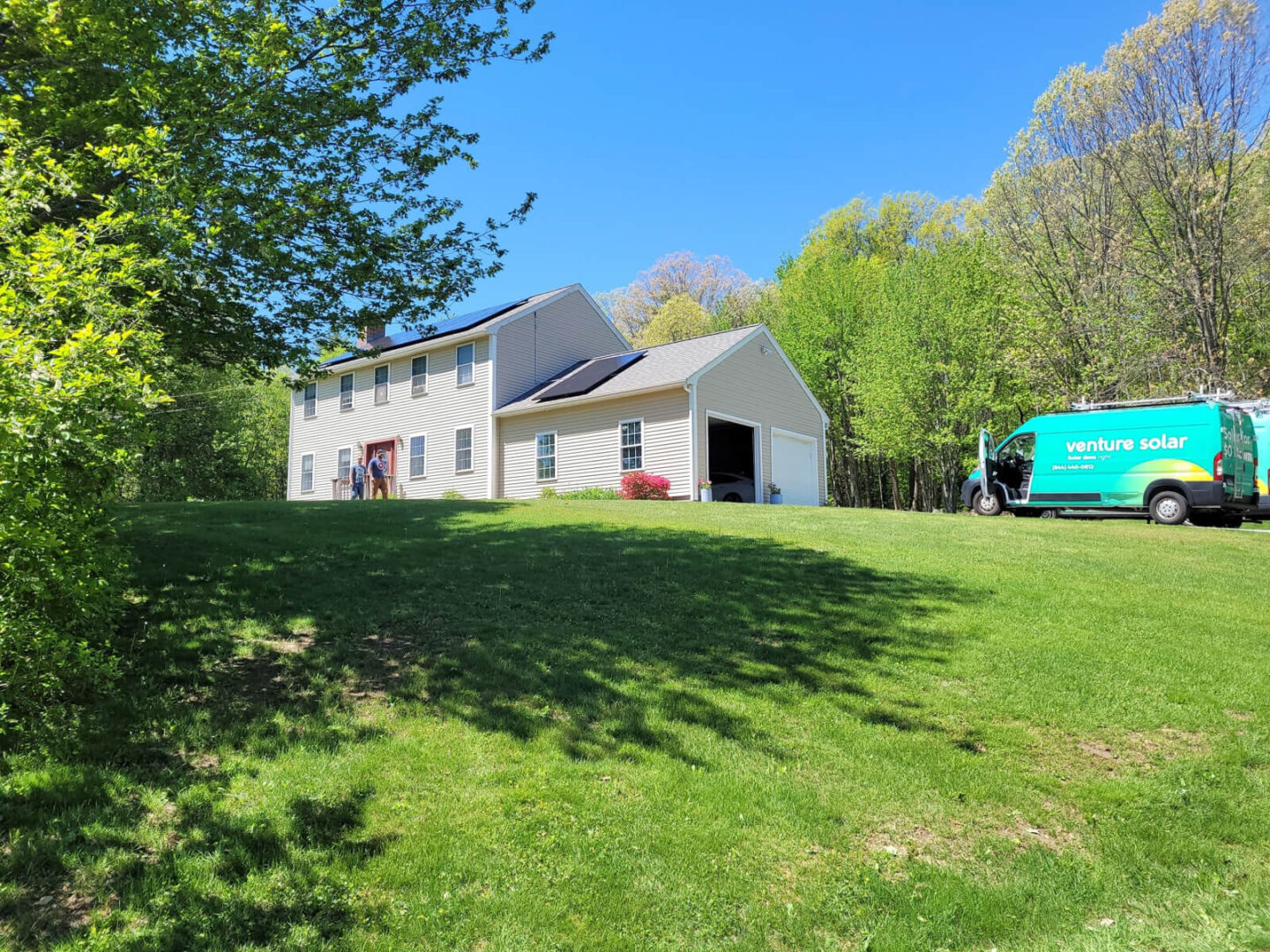 A home with a Venture Home truck parked outside and solar panels installed on the roof.

