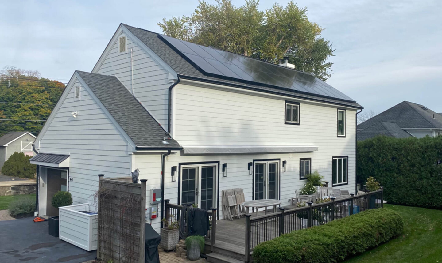 A view of a home from the back, showcasing solar panels installed on the roof.