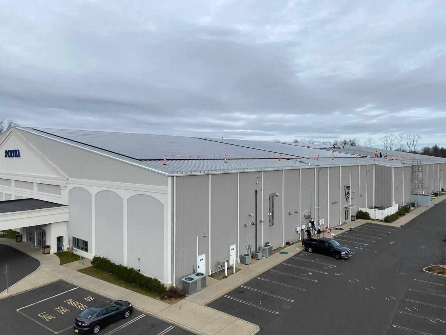 Electric vehicles plugged into charging stations outside a building.