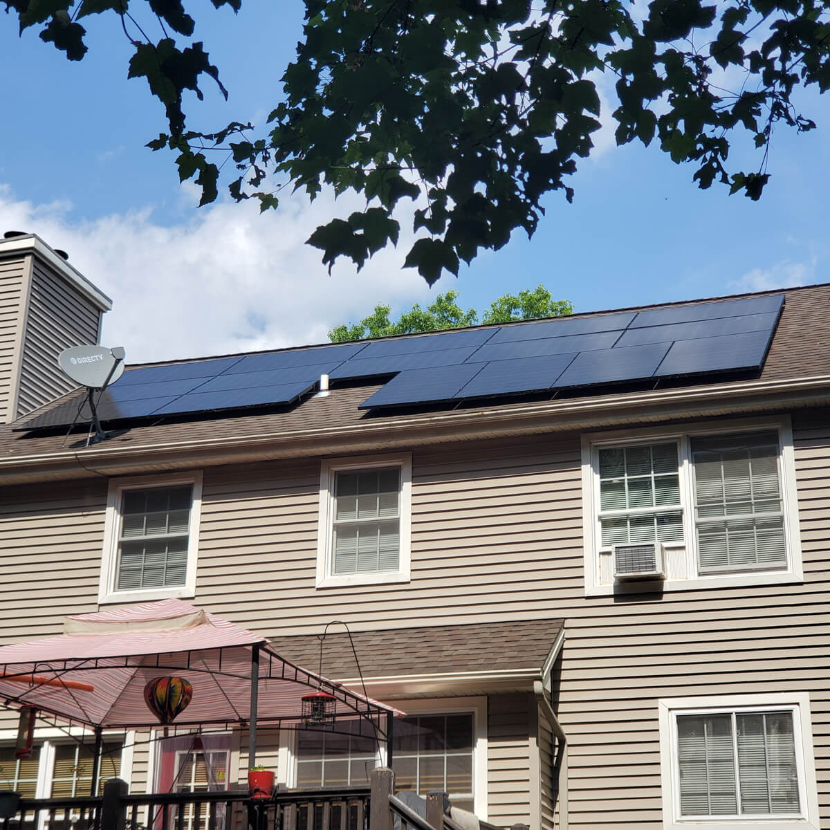 A home with solar panels installed on the roof, viewed from the back porch, showcasing sustainable energy use.