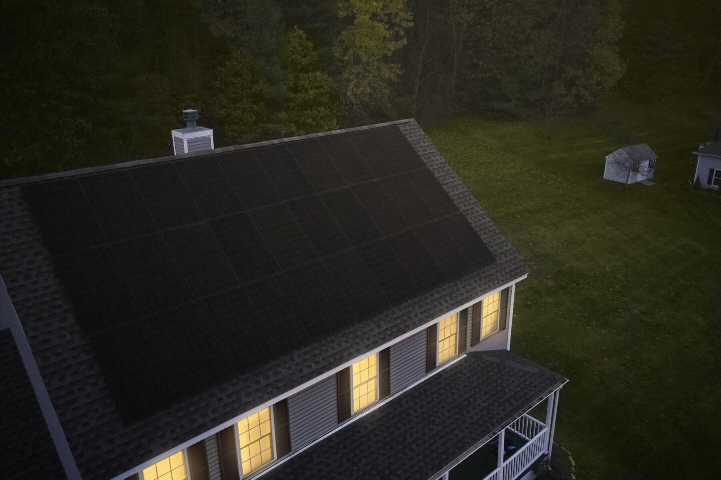 Solar panels installed on a large tan home with sunlight streaming through the windows.