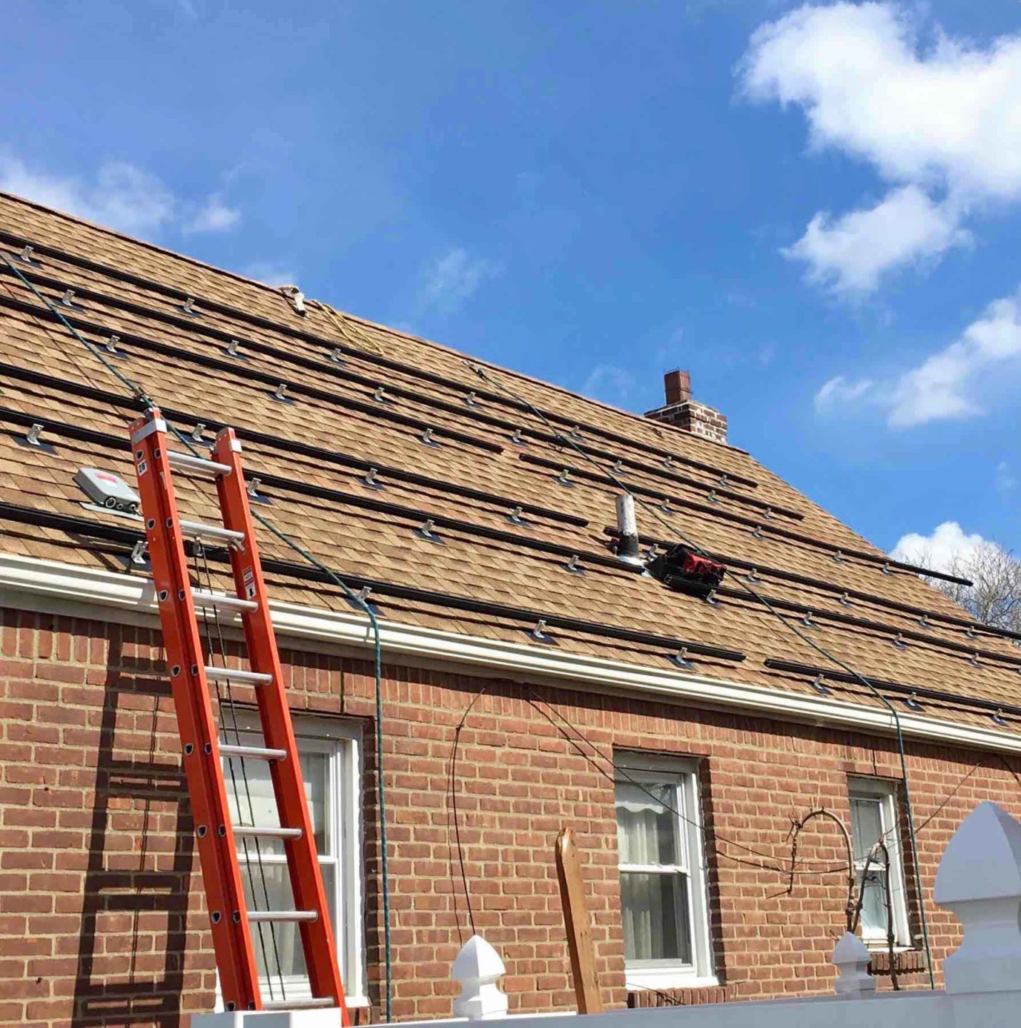 Venture Home workers placing equipment on the roof as part of a solar panel installation.