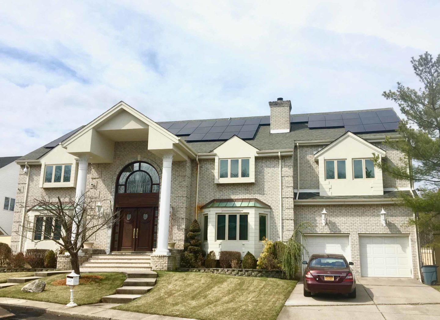 A beautiful, luxurious home with solar panels on the roof, promoting clean energy.