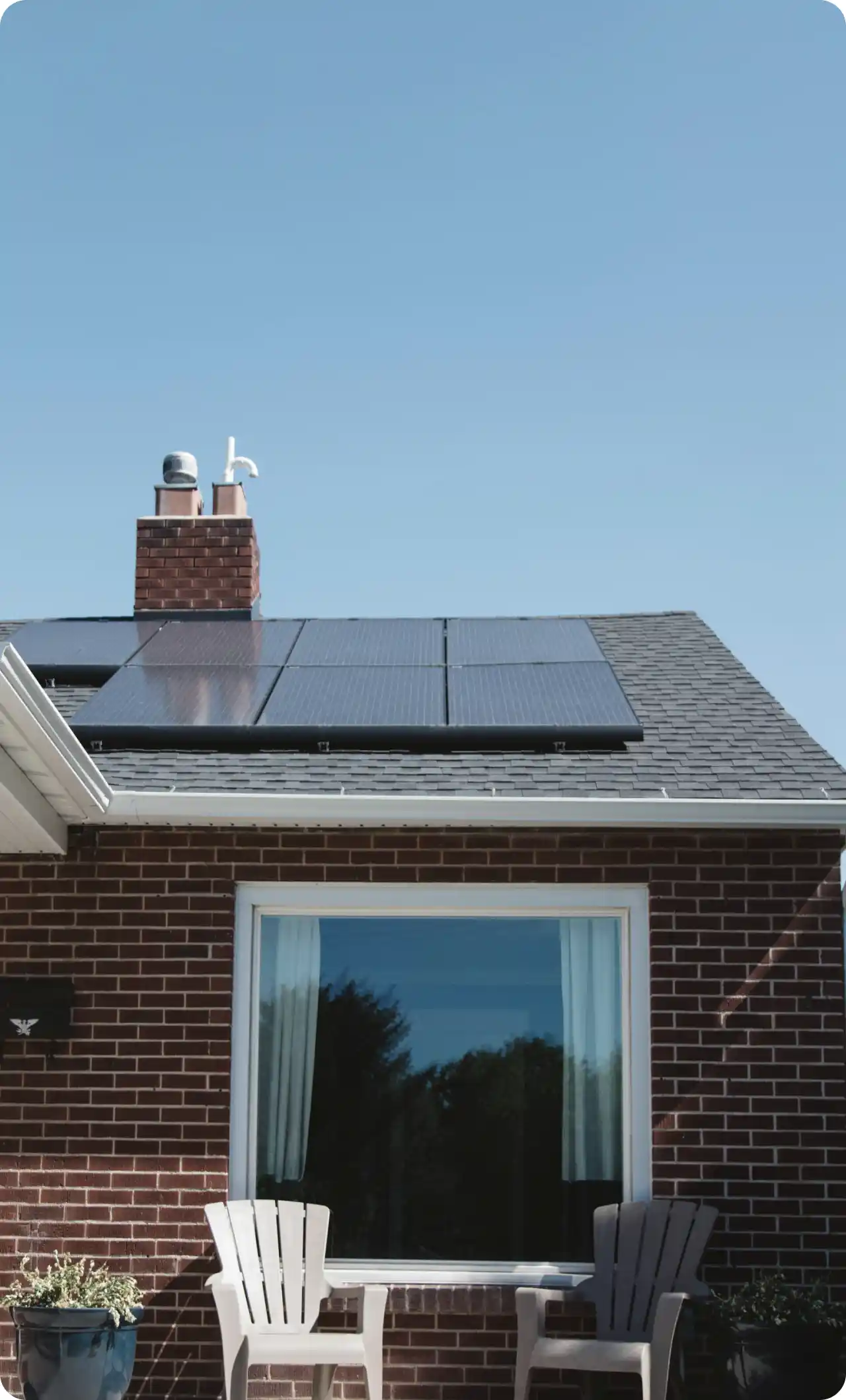 A brick home with solar panels installed on the roof, harnessing renewable energy for the property.