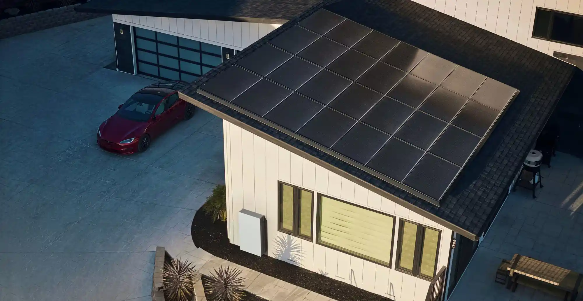 Aerial view of a modern white house with solar panels, showcasing efficient solar installation pricing.