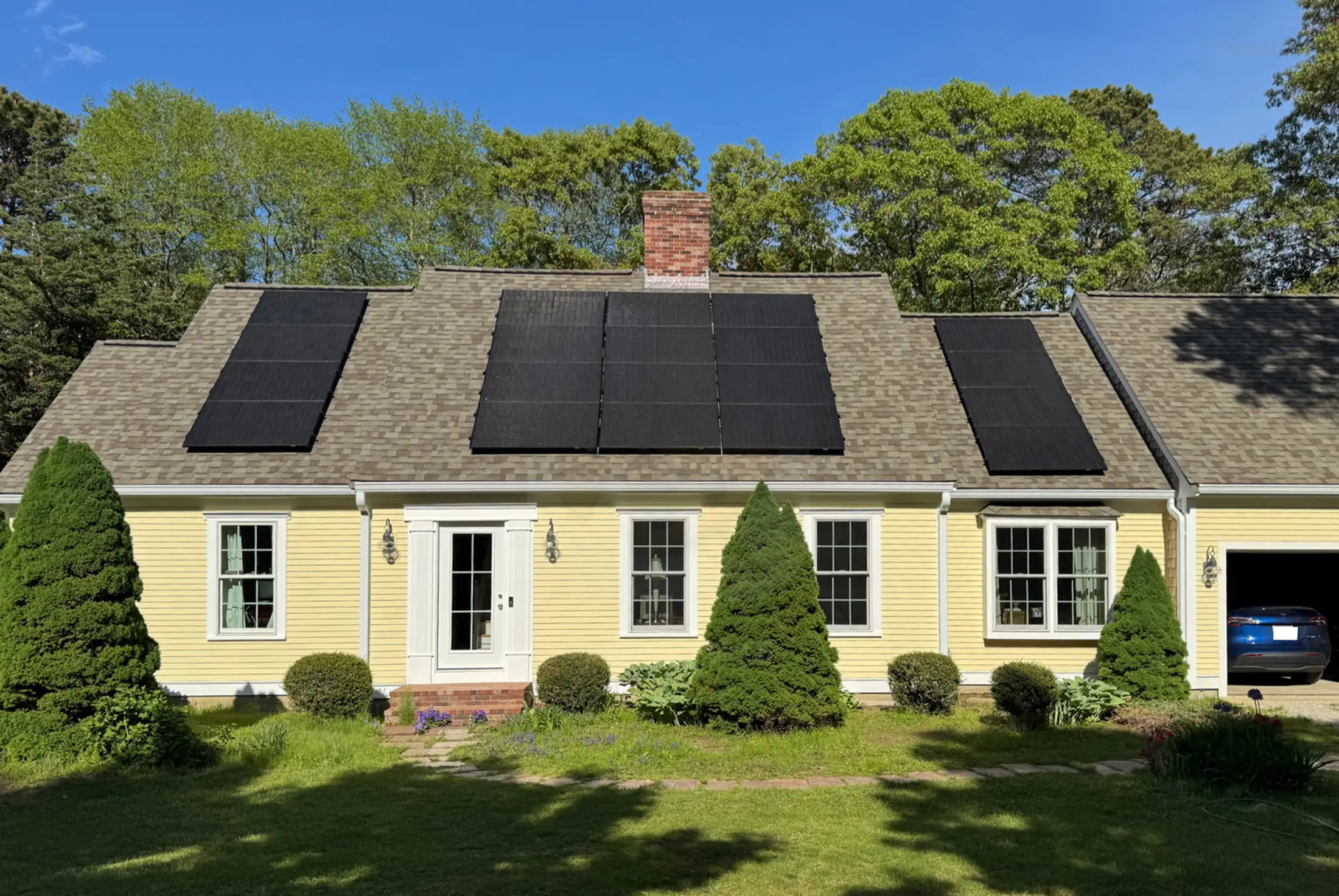 A yellow, one-story house with solar panels on the roof, reflecting New York solar incentives.